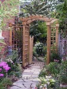 A simple garden arbor with gate detail and trelliswork side screens