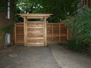 A horizontal board fence with pergola top